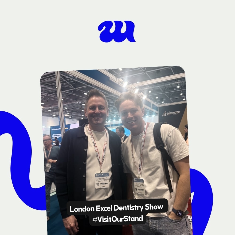 Two men smiling at London Excel Dentistry Show exhibit hall